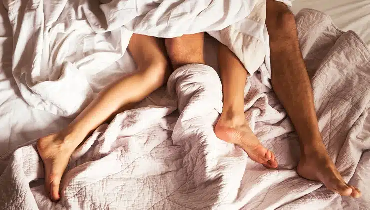 man and woman's legs tangled in sheets