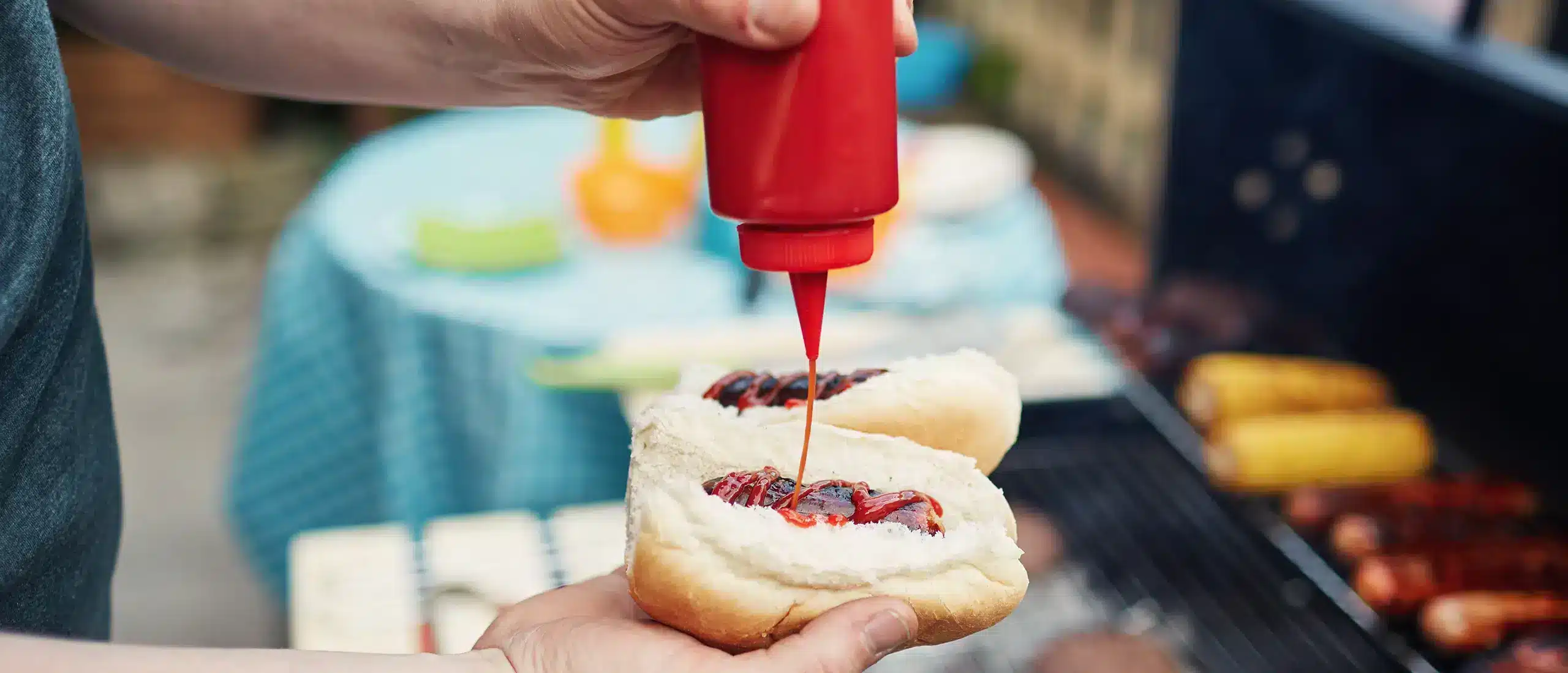 Man squirting ketchup on a hotdog