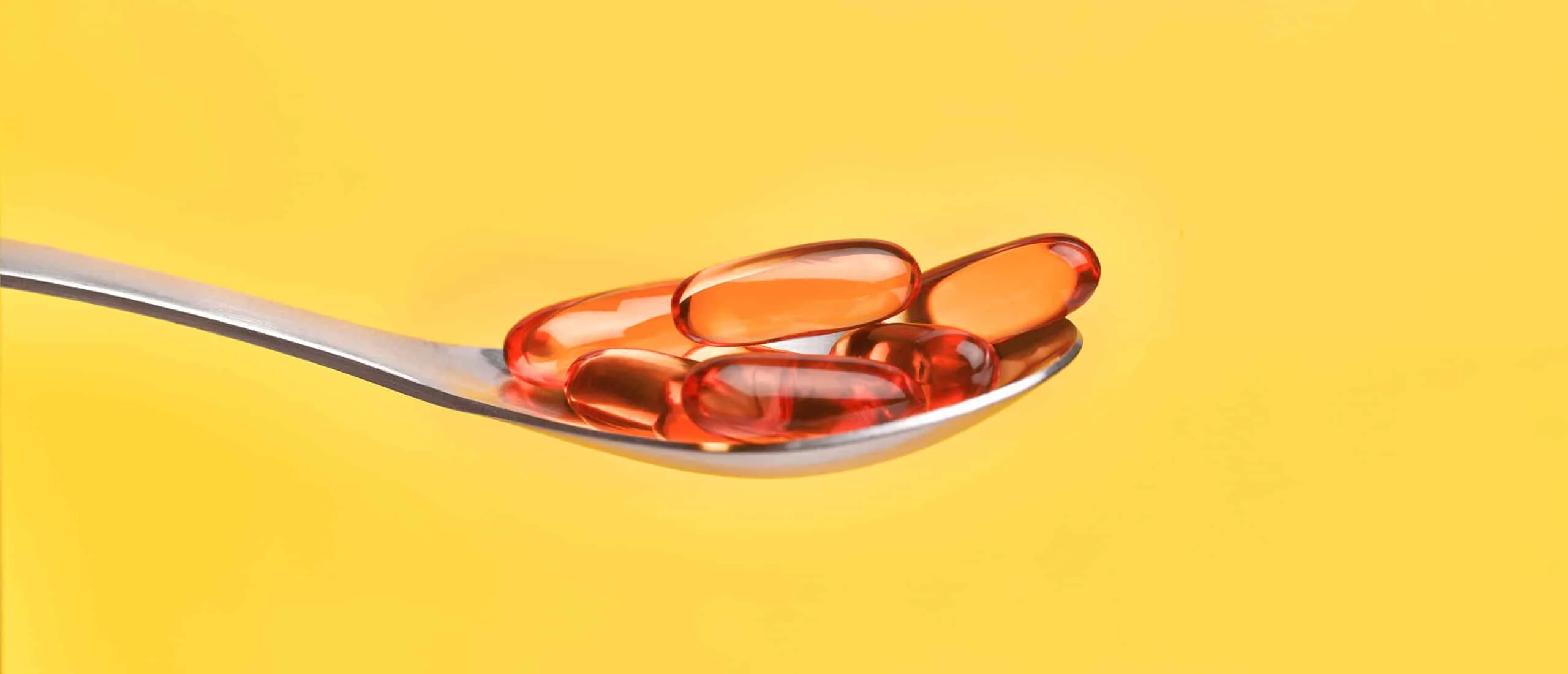 A spoon with vitamin D capsules on it