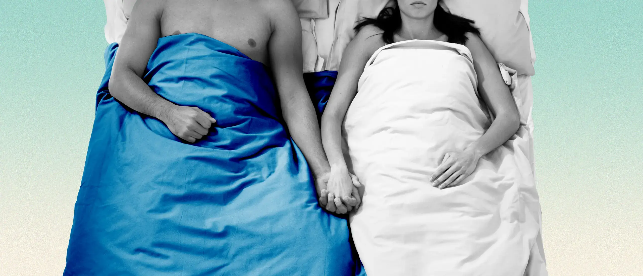 a couple lies in bed next to each other holding hands
