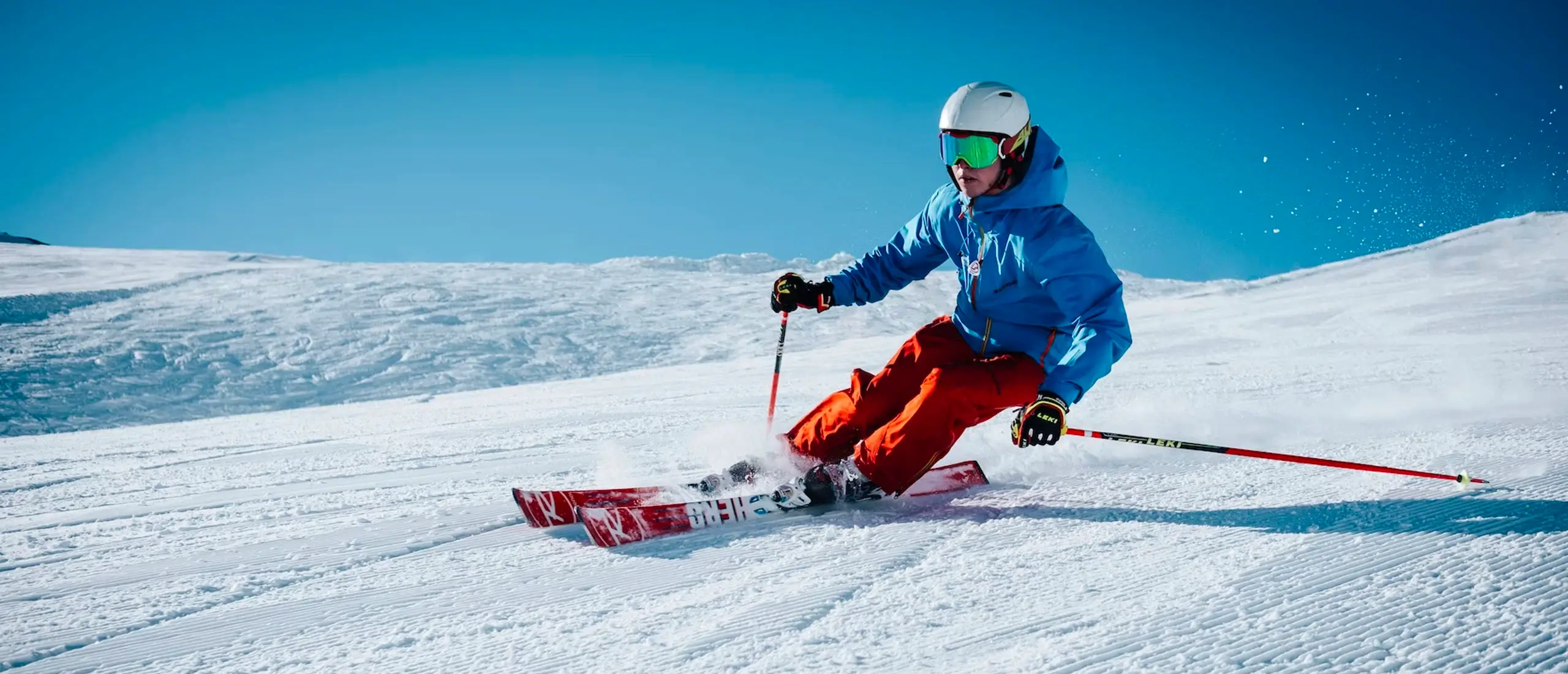 Downhill skiier skiing down slope