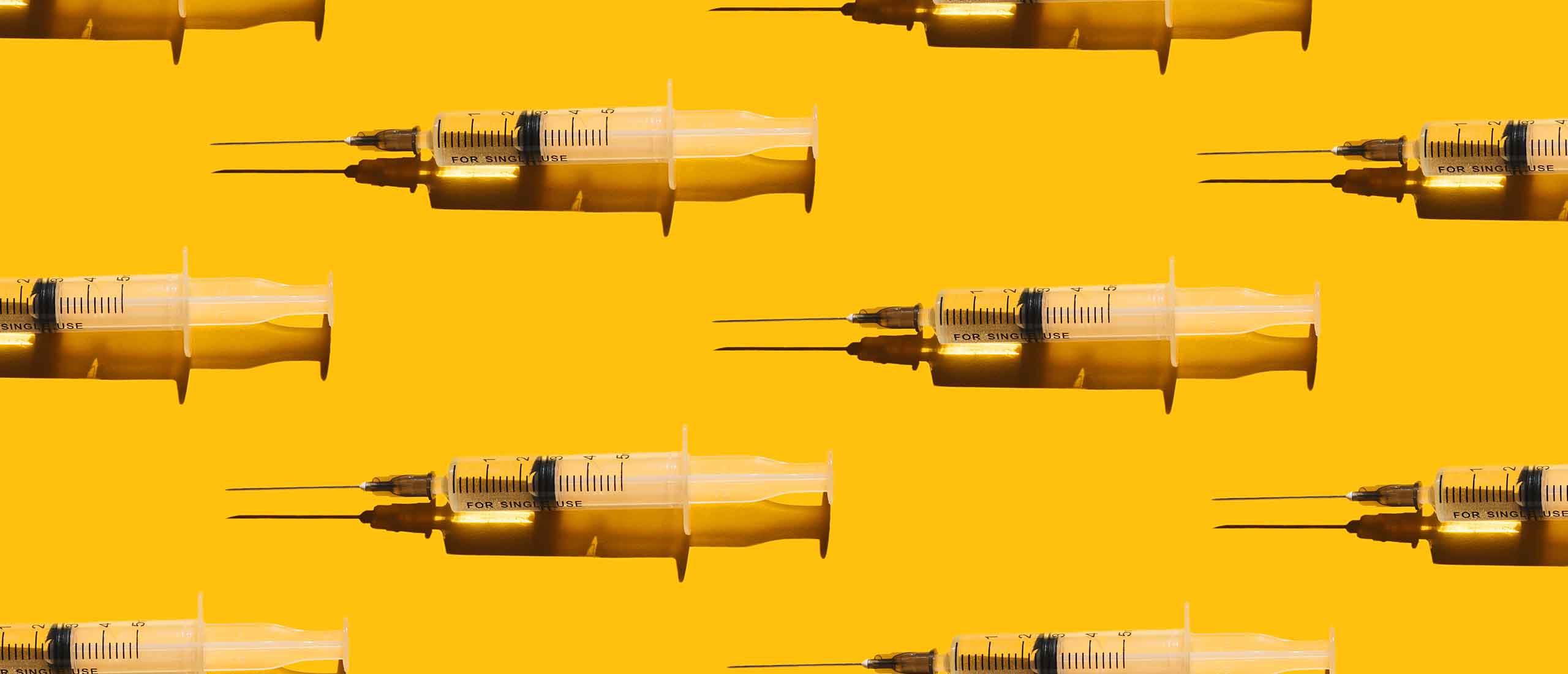 Syringes spread out over yellow counter