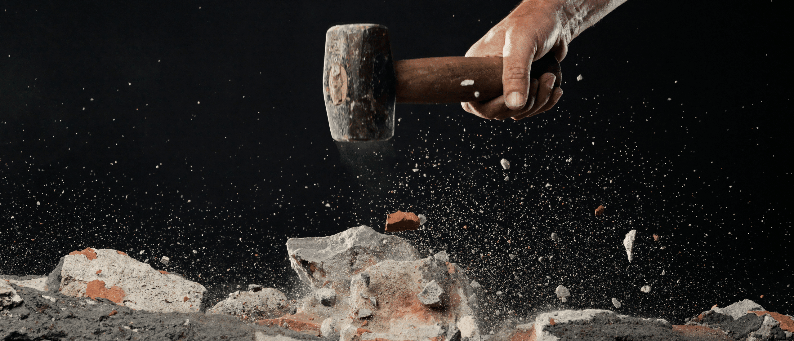 person smashing rocks with hammer