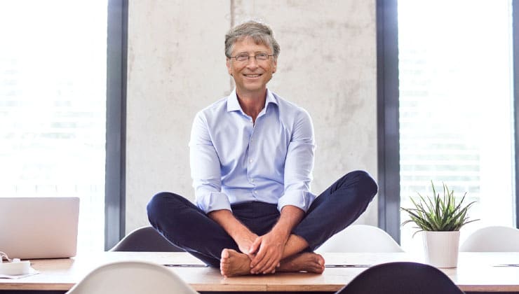 Bill Gates meditating on top of desk