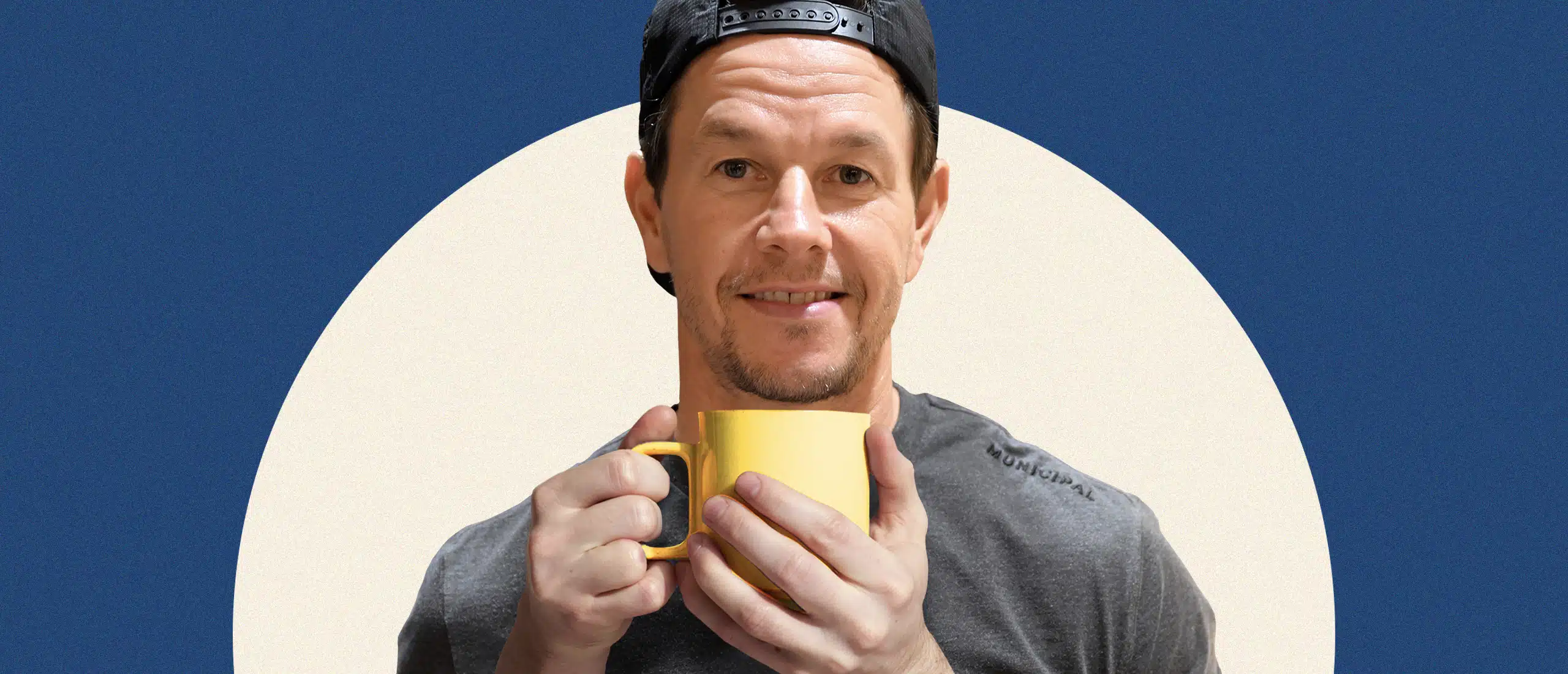 Mark Walhberg holding a cup of coffee lovingly