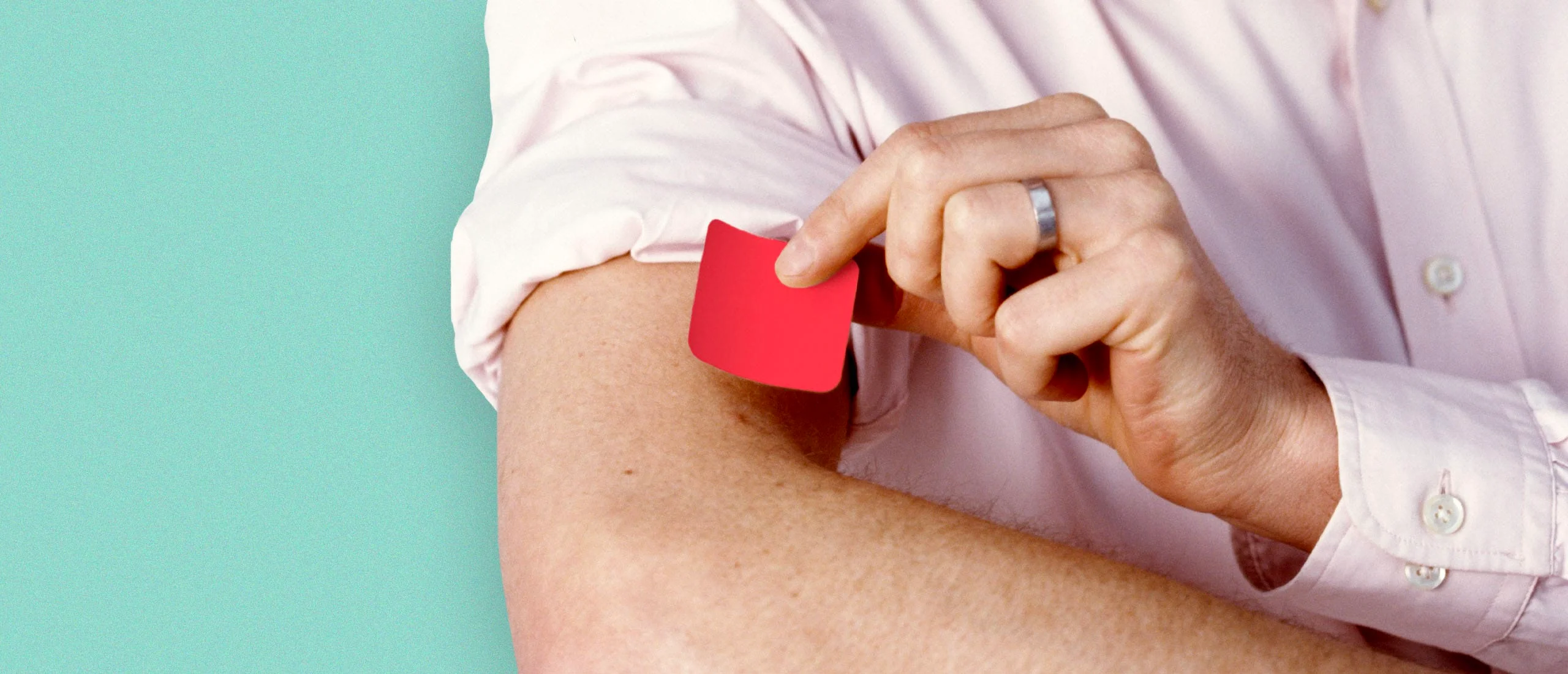 A man putting a testosterone patch on his arm.